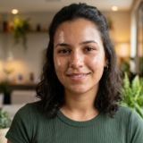 Mulher sorrindo com creme facial aplicado nas bochechas
